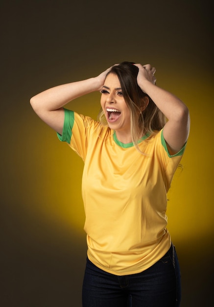 Braziliaanse fan Braziliaanse vrouw fan vieren in voetbal of voetbalwedstrijd op gele achtergrond Brazilië kleuren