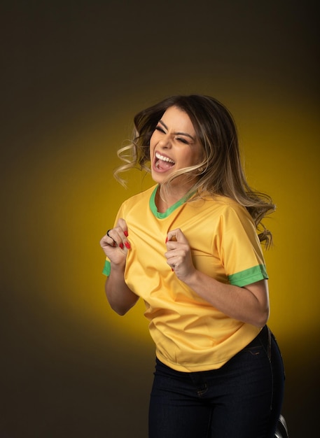 Braziliaanse fan Braziliaanse vrouw fan vieren in voetbal of voetbalwedstrijd op gele achtergrond Brazilië kleuren