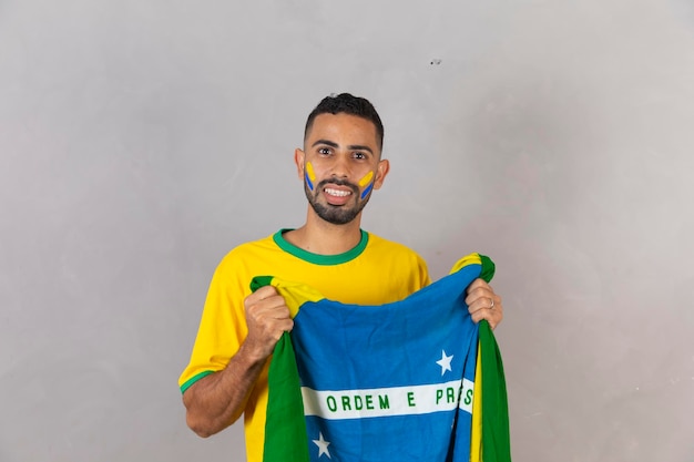 Braziliaanse fan met Braziliaanse vlag glimlachend in de camera