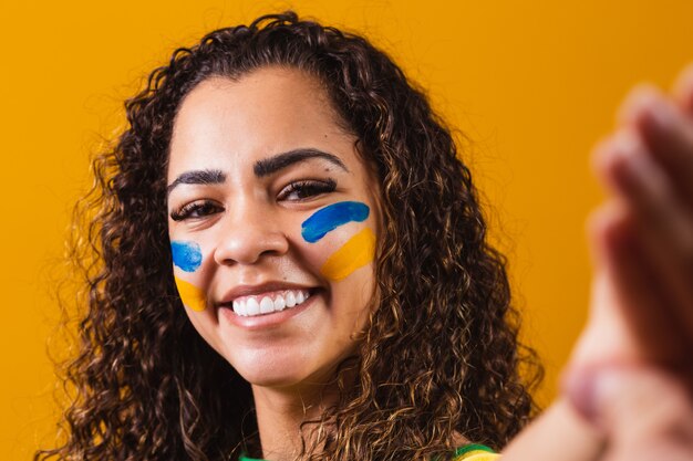 Braziliaanse fan met geschilderd gezicht die een selfie maakt