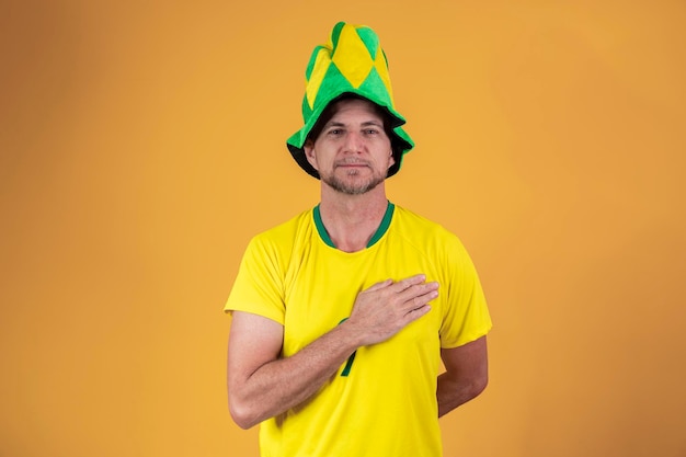 Braziliaanse fan met hand op borst die het volkslied zingt