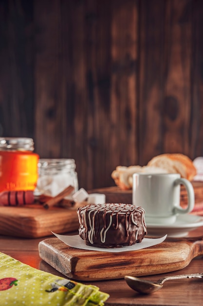 Braziliaanse honing koekjes chocolade bedekt op de houten tafel met koffie en honingbij - Pao de mel