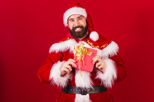 Braziliaanse kerstman jonge blanke man met rood geschenk