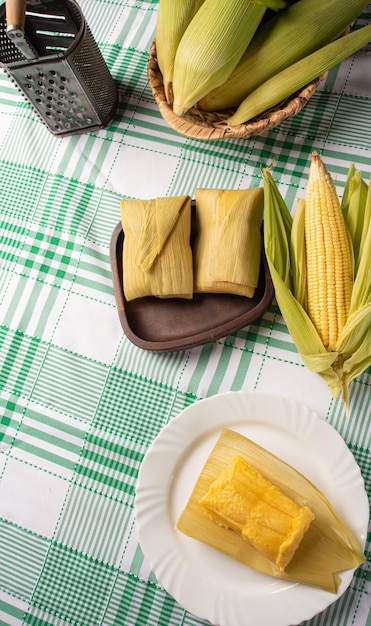 Braziliaanse maïssnack pamonha en korenbloem gerangschikt op een tafel met groen en wit tafelkleed Bovenaanzicht