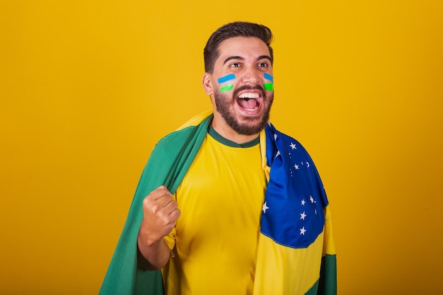 Braziliaanse man Latijns-Amerikaans juichen voor Brazilië in het WK 2022 fan brunette vieren vibrerend gelukkig schreeuwend doelpunt knap