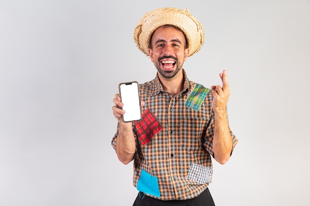 Braziliaanse man met festa junina-kleding Arraial Feest van Sint-Jan met smartphone met wit scherm