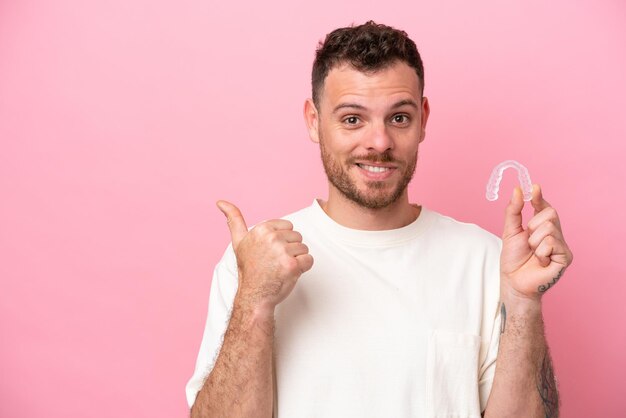 Braziliaanse man met onzichtbare beugel die naar de zijkant wijst om een product te presenteren