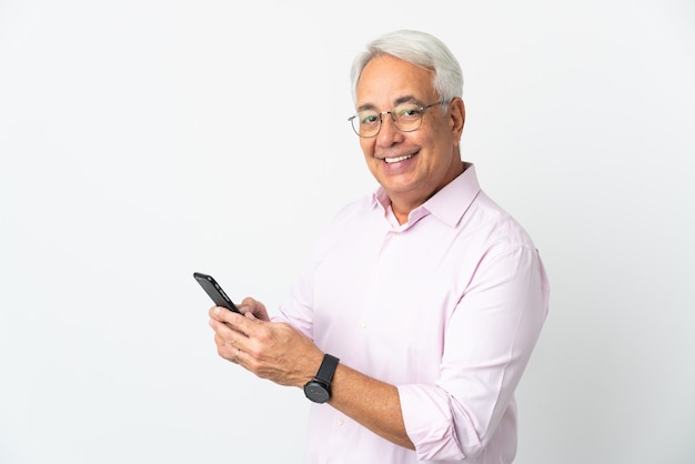 Braziliaanse man van middelbare leeftijd geïsoleerd op een witte achtergrond die een bericht of e-mail verzendt met de mobiel