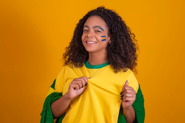 Braziliaanse supporter Braziliaanse vrouw fan viert op voetbal of voetbalwedstrijd op gele achtergrond Brazilië kleuren