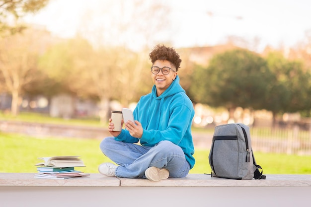 Braziliaanse universiteitsstudent geniet van koffie en gebruikt zijn smartphone buiten