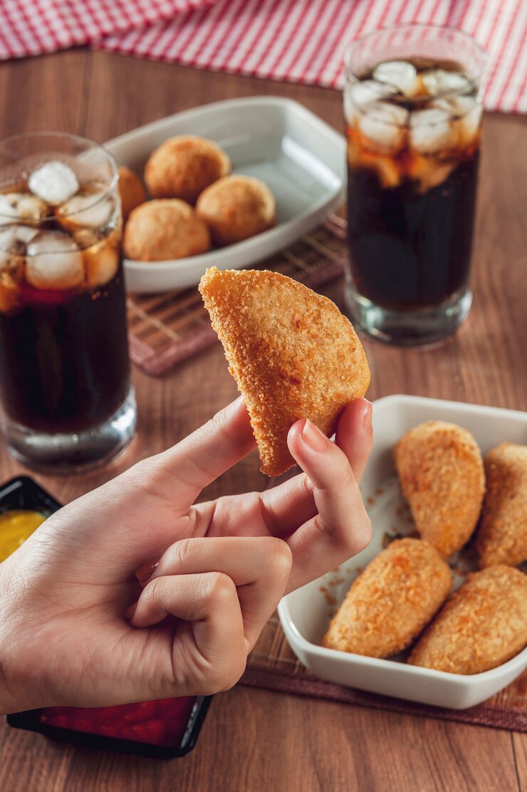 Braziliaanse voorgerecht gefrituurde rundvleeskroket met twee glazen drank