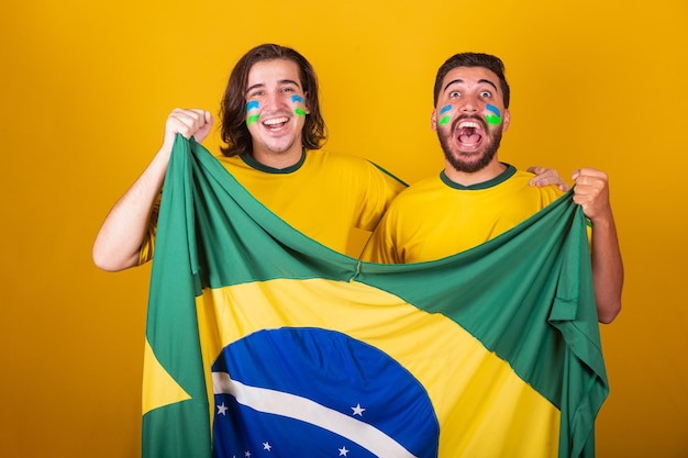 Braziliaanse vrienden latijns-amerikanen diversiteit juichen voor brazilië WK 2022 met braziliaanse vlag voetbal juichen en trillend schreeuwend doel blij en gelukkig