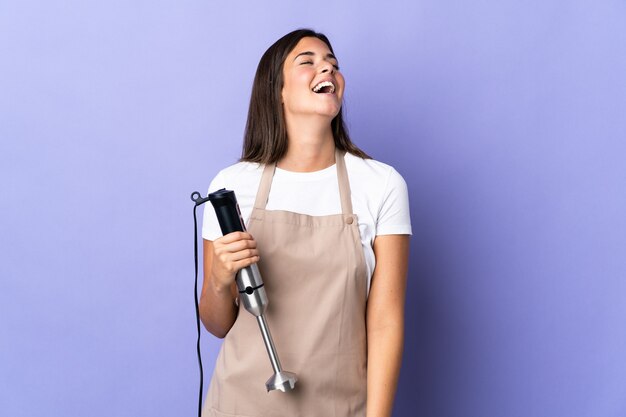 Braziliaanse vrouw die geïsoleerde handmixer gebruikt