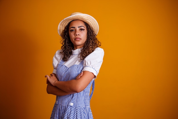 Braziliaanse vrouw die typische kleren voor festa junina met dwarsarmen draagt