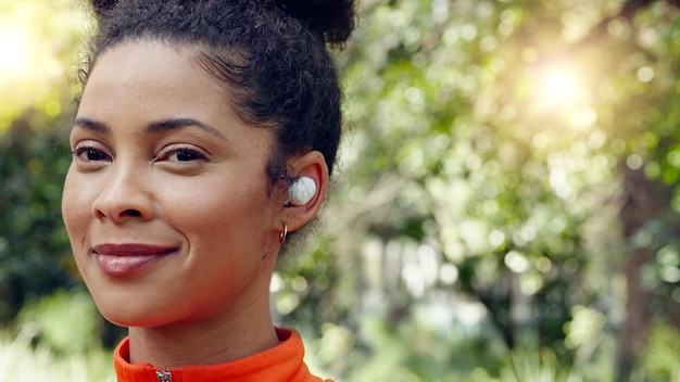 Foto braziliaanse vrouw oortelefoons en muziek in fitness training bos achtergrond training en natuurpark oefening face zoom gelukkige glimlach of hardloper met wellness sportdoelen motivatie en radiopodcast