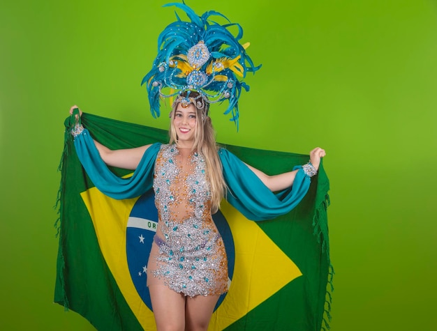 Braziliaanse vrouw poseren in samba kostuum op groene achtergrond met de vlag van Brazilië