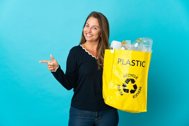 Braziliaanse vrouw van middelbare leeftijd met een zak vol plastic flessen