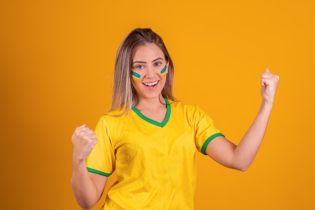 Braziliaanse vrouw viert feest op gele achtergrond met beschilderd gezicht