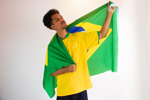 Braziliaanse zwarte man fan met voetbalteam shirt geïsoleerd op wit