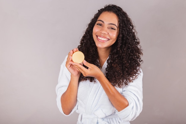 Braziliaanse zwarte vrouw draagt badjas en handdoek veganistische producten voor schoonheids- en huid- en haarverzorgingszepen Spa zelfzorg welzijn