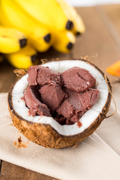 Aã§ai brasiliano su un guscio di noce di cocco con uno sfondo di legno e frutti.