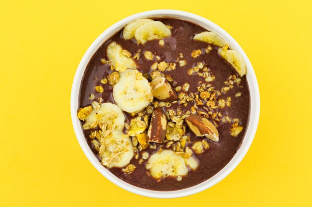 Brazilian aãâ§ai in a white bowl with banana, granola and chestnuts.