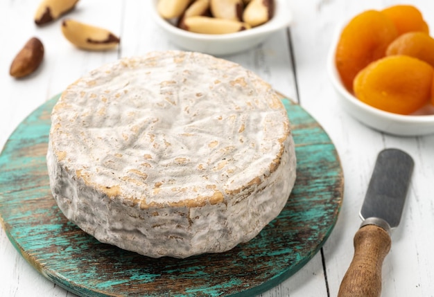 Brazilian artisan Bofete blue cheese with bread nuts and fruits over wooden table