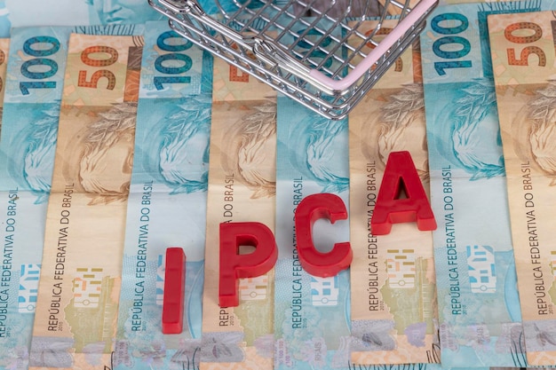 ブラジルの紙幣 50 と 100 レアルの紙幣は、ポルトガル語で Indice Nacional de Precos ao consumidor を赤で意味する頭字語 IPCA を背景に