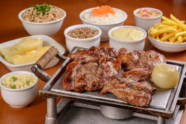 Brazilian barbecue steak roasted on the grill served with traditional Brazilian dishes