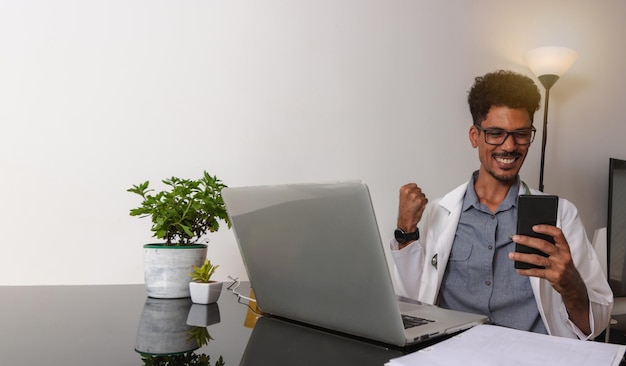 Brazilian Black Doctor or Veterinarian Working at Home Young Man During the day at desk With Laptop