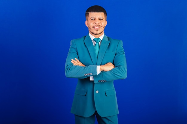 Brazilian black man dressed in a suit and blue tie business man With arms crossed optimistic and confident