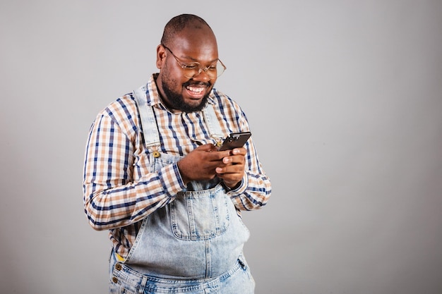 Brazilian black man holding smartphone browsing apps app mobile