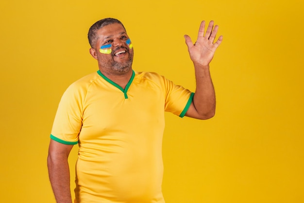 Brazilian black man soccer fan from brazil waving greeting from afar