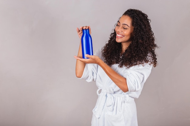 Brazilian black woman wearing bathrobe and towel curly hair spa\
beauty center hair care hair products