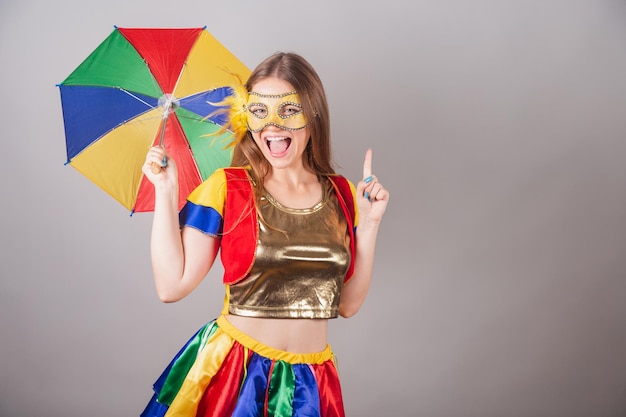 Brazilian blonde woman dressed in frevo clothes carnival mask\
dancing with frevo umbrella