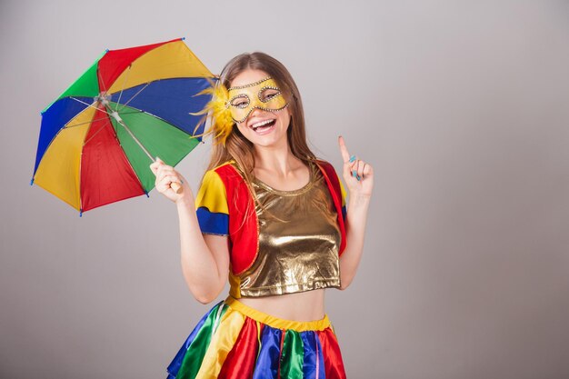 Brazilian blonde woman dressed in frevo clothes carnival mask\
dancing with frevo umbrella