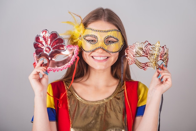 Brazilian blonde woman dressed in frevo clothes carnival mask\
holding carnival masks closeup shot of the face
