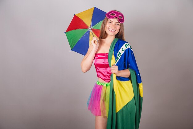 ブラジルの国旗とピンクのカーニバルの服フレボ傘に身を包んだブラジルの金髪女性