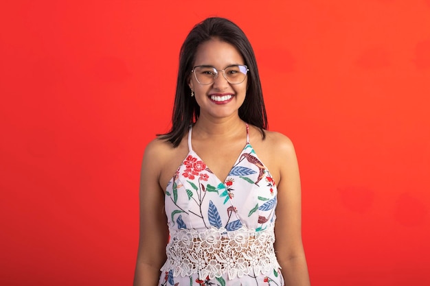 Brazilian brunette woman in flower print dress in studio wearing eyeglasses and sunglasses