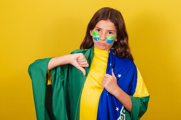 ブラジルの白人の子供は不承認の否定的な悲しい不幸なワールドカップオリンピックのサッカーファンを親指で下ろします
