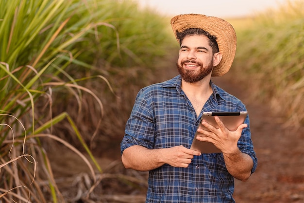 Brazilian caucasian man farmer rural worker agricultural engineer holding tablet and looking at the sky Agriculture and technology