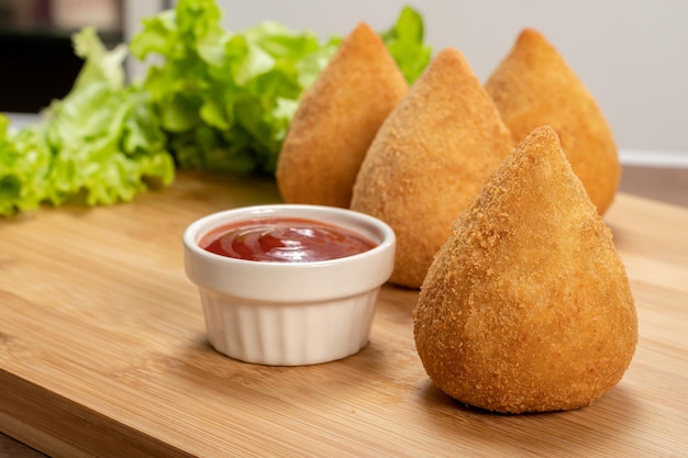 木の板にカチュピリ伝統的なブラジルのスナックとブラジル チキン coxinha