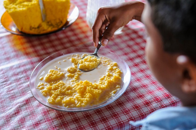 Brazilian child consuming corn couscous with milk Popular dish Brazil