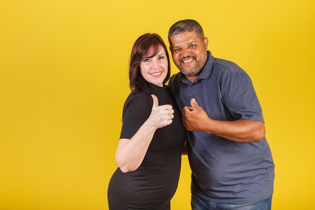 Brazilian couple caucasian woman and black man thumb up like positive we love