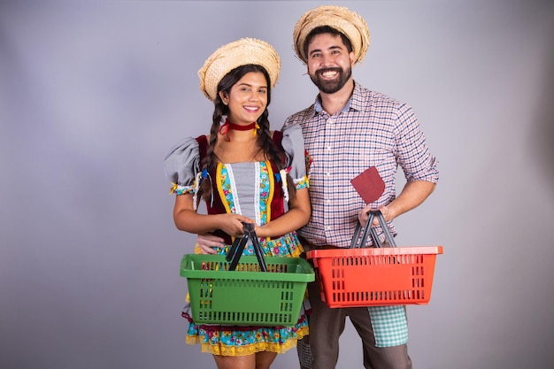 Бразильская пара в одежде от festa junina arraial festa de sao joao парень и девушка с покупками в рыночной корзине