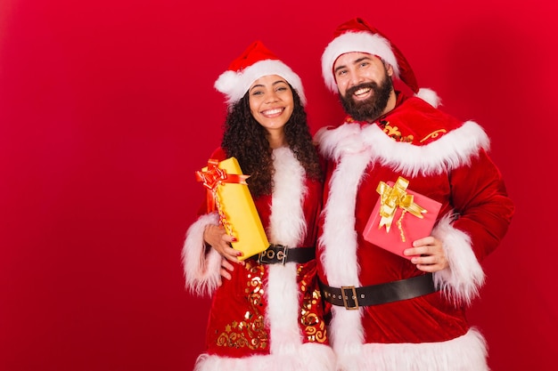 Brazilian couple dressed for christmas santa claus mummy claus exchanging gifts approved black woman and caucasian man