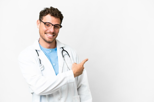 Brazilian doctor man over isolated white background pointing back