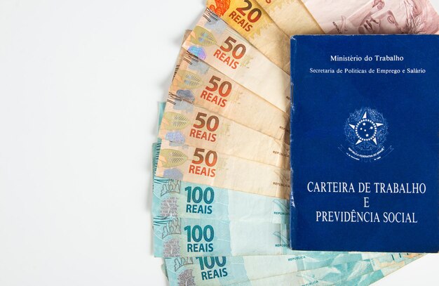 Brazilian document work and social security Carteira de Trabalho e Previdencia Social with Brazilian money banknotes