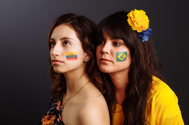 얼굴에 바디 아트가 있는 브라질 및 에콰도르 여성들이 기대하는 다채로운 그림 선택적 초점