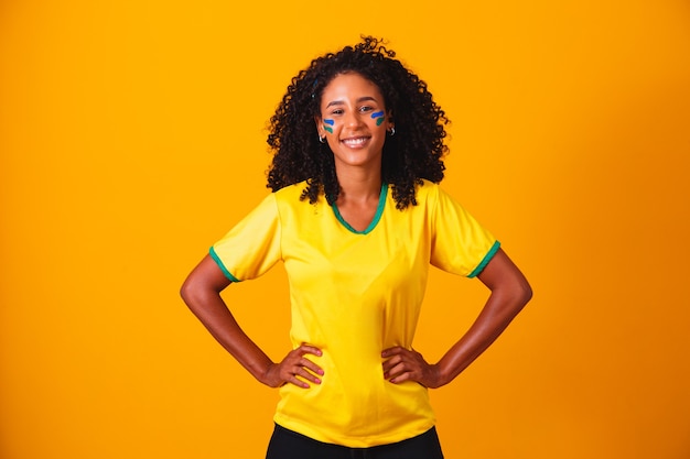 Brazilian fan. Brazilian fan celebrating football or soccer game on yellow background. Colors of Brazil.